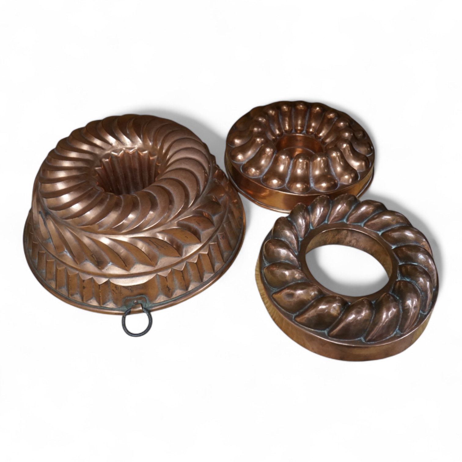 Three Victorian copper jelly moulds, largest 26cm in diameter. Condition - some minor knocks